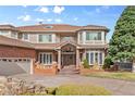 Beautiful home featuring brick accents, a three-car garage, and manicured landscaping leading to the front entrance at 132 Loveland Way, Golden, CO 80401