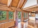 Inviting interior with log walls, vaulted ceilings, wood floors, large windows, and access to a deck at 1000 Lodgepole Dr, Evergreen, CO 80439