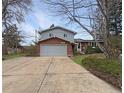 Two story house with a large gray garage door, brick facade, and concrete driveway at 6501 Welch Ct, Arvada, CO 80004