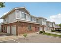 Condo exterior featuring brick and siding with garage doors and parking in front at 10129 W 55Th Dr # 3, Arvada, CO 80002