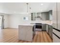 Bright kitchen featuring a center island, modern appliances, and open layout into the living area at 1430 S Glencoe St, Denver, CO 80222