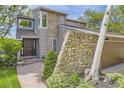 Exterior of a two-story home with stone and wood siding and a brick walkway at 1540 W Briarwood Ave, Littleton, CO 80120