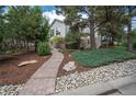 A nicely landscaped home with a stone path that leads to the property, with mature trees on the property at 1030 Timbercrest Dr, Castle Pines, CO 80108