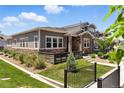 Exterior view of the home showcasing the stone and siding architecture and manicured landscaping at 15501 E 112Th Ave # 6F, Commerce City, CO 80022