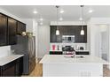 Modern kitchen with stainless steel appliances, center island, and sleek dark cabinetry providing ample space at 15501 E 112Th Ave # 6F, Commerce City, CO 80022
