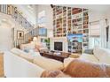 Comfortable living room with floor-to-ceiling bookshelf, fireplace, and large windows at 1455 Flowers Ct, Erie, CO 80516