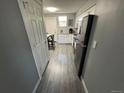 Efficient kitchen featuring white cabinetry, modern appliances, granite countertops, and gray wood-look flooring at 9440 E Girard Ave # 1, Denver, CO 80231