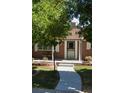 Charming brick home with landscaped front yard, sidewalk and covered porch at 2694 S Krameria St, Denver, CO 80222