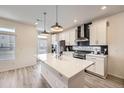 Modern kitchen with a large island, stainless steel appliances, and sleek cabinetry at 10196 Worchester St, Commerce City, CO 80022