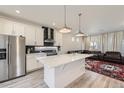 Modern kitchen featuring stainless steel appliances, a large island, and an open layout to the living area at 10196 Worchester St, Commerce City, CO 80022