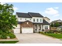 Stylish two-story home with stone accents, a well-kept lawn, and an attached three-car garage at 23421 E Rockinghorse Pkwy, Aurora, CO 80016