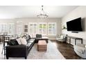 Open living room boasts large windows, modern decor, and a comfortable leather sectional at 23421 E Rockinghorse Pkwy, Aurora, CO 80016