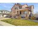 Two-story home with a well-manicured lawn, stone accents, and a welcoming front porch at 20145 E Fair Ln, Centennial, CO 80016