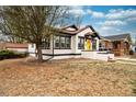 Charming bungalow featuring a bright yellow front door, contrasted by black trim and a classic design at 1401 Ash St, Denver, CO 80220