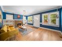 Bright living room featuring hardwood floors, a cozy fireplace, and abundant natural light at 1401 Ash St, Denver, CO 80220