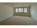 Cozy bedroom with plush carpeting and three windows offering natural light and neighborhood views at 767 Raindance St, Erie, CO 80516