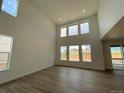 Bright living room featuring high ceilings, large windows, and wood flooring at 767 Raindance St, Erie, CO 80516