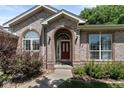 Inviting front entrance with a brick archway and a red front door at 329 Bobcat Pt, Lafayette, CO 80026