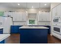 Well-equipped kitchen featuring a central island with a cooktop and white cabinets at 329 Bobcat Pt, Lafayette, CO 80026