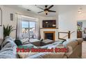 A cozy living room features a fireplace, a ceiling fan, a large sectional sofa, and a sliding glass door to a balcony at 4100 Albion St # 221, Denver, CO 80216