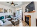 A comfortable living room features a fireplace, a large TV, a ceiling fan, and balcony access at 4100 Albion St # 221, Denver, CO 80216