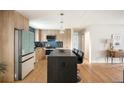 Modern kitchen with stainless steel appliances, wooden cabinets, and a sleek island at 815 S Jersey St, Denver, CO 80224