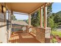 Inviting covered porch features wood flooring, brick pillars, and views of the surrounding nature at 165 Washington St, Golden, CO 80403