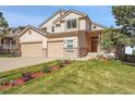 Two-story home featuring a three-car garage, manicured lawn, and a welcoming entrance at 165 Washington St, Golden, CO 80403