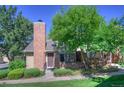 Charming home exterior with a brick chimney, mature tree, and lovely landscaping creates a picturesque and inviting curb appeal at 11884 Elk Head Range Rd, Littleton, CO 80127