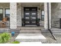 Charming front entrance with a double front door, stone columns, and a cozy seating area at 27250 E Nova Cir, Aurora, CO 80016