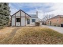 A charming home featuring Tudor-style accents, a well-manicured lawn, and mature landscaping at 1190 Glencoe St, Denver, CO 80220