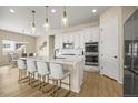 Well-lit kitchen showcases a large island with barstool seating, stainless appliances, and white cabinets at 2766 Keepsake Way, Castle Rock, CO 80109