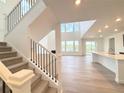 Bright, open-concept living room featuring beautiful hardwood floors, large windows, and a staircase at 3967 Descent St, Castle Rock, CO 80108