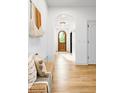 Bright foyer with hardwood floors, a decorative tapestry, and an arched doorway leading further inside at 659 Albion St, Denver, CO 80220