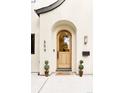 Inviting front entrance with an arched wooden door, stylish house numbers, and manicured topiaries at 659 Albion St, Denver, CO 80220