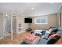 Inviting basement area with a large sectional couch, entertainment center and walk-up access to the backyard at 15541 E Cornell Ave, Aurora, CO 80013