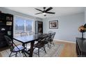 The dining room boasts hardwood floors, a black bookshelf, and plenty of natural light from the window at 15541 E Cornell Ave, Aurora, CO 80013