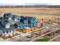Bright blue two-story home with solar panels and fenced yard in Primary planned community at 5965 Hanover St, Denver, CO 80238