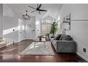 Bright living room featuring a vaulted ceiling, hardwood floors, large windows and a comfortable couch at 7586 Halleys Dr, Littleton, CO 80125