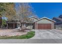 Attractive home featuring a two-car garage, brick accents and a mix of green and brown siding, enhancing curb appeal at 7444 S Milwaukee Ct, Centennial, CO 80122