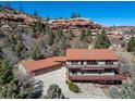 Two-story home with an attached three car garage, a red tiled roof, wooden decks and green siding at 6601 Pike Cir, Larkspur, CO 80118