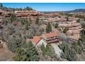 Two-story home with an attached three car garage, a red tiled roof and siding surrounded by trees at 6601 Pike Cir, Larkspur, CO 80118