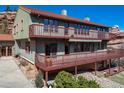 Close-up view of home's exterior, featuring wood decks, siding, a tiled roof and decorative foliage at 6601 Pike Cir, Larkspur, CO 80118