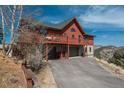 Exterior of mountain home with attached garage and deck overlooking mountain views at 804 Clear Creek Rd, Evergreen, CO 80439