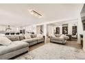 Spacious living room with large sectional sofa and adjacent home office at 6506 Barnstead Dr, Castle Pines, CO 80108