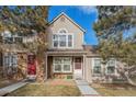 Two-story townhome with red door and walkway at 9691 W Chatfield Ave # E, Littleton, CO 80128