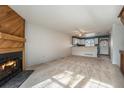 Bright living room with fireplace and view into kitchen at 9691 W Chatfield Ave # E, Littleton, CO 80128