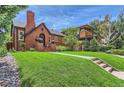 Quaint brick home with a well-manicured lawn and sidewalk, showcasing curb appeal at 1218 S Josephine St, Denver, CO 80210