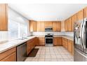 Well-lit kitchen with stainless steel appliances, tile countertops, and ample cabinet space at 13180 Jasmine St, Thornton, CO 80602