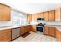 Well-lit kitchen with stainless steel appliances, tile countertops, and ample cabinet space at 13180 Jasmine St, Thornton, CO 80602